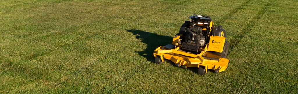 Robotic lawn mower mowing grass on open grounds.