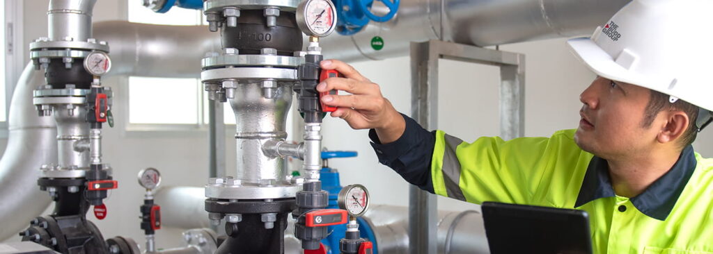 worker inspecting pressure valves